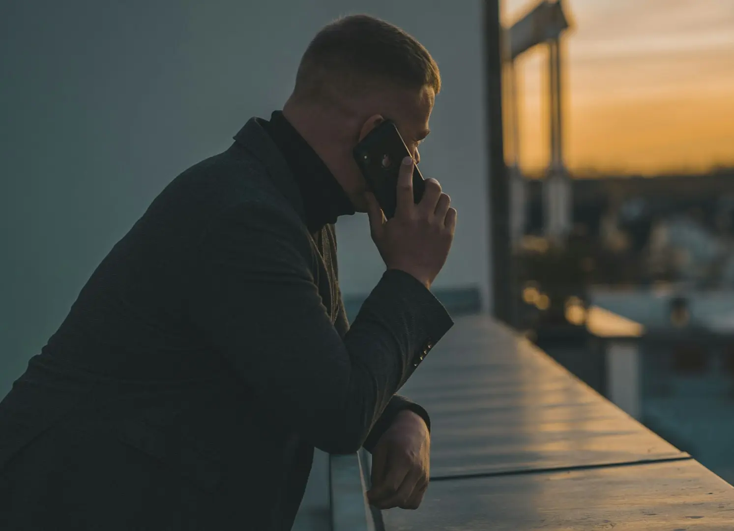 man in black long sleeve shirt sitting by the table